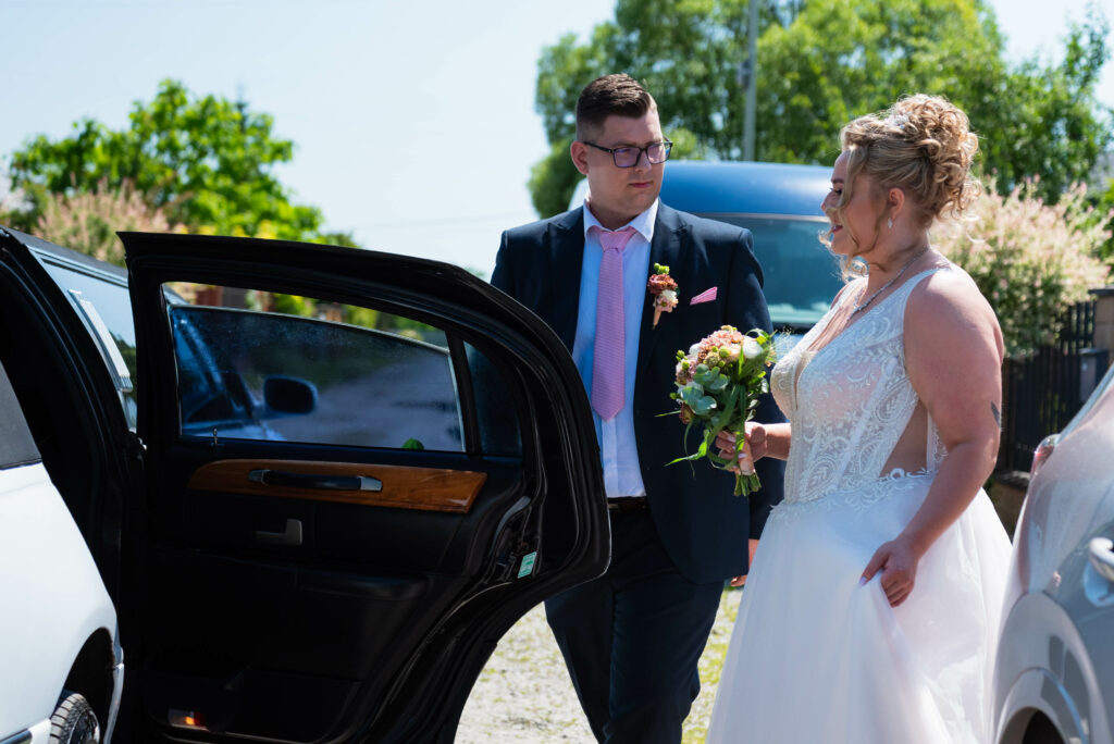 para młoda przy limuzynie, portret pary młodej, limuzyna